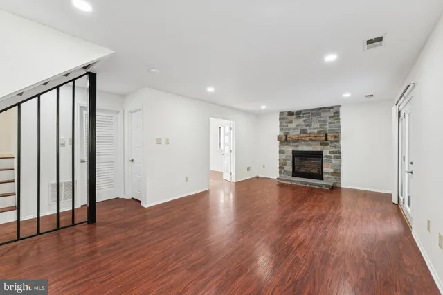 a view of empty room with wooden floor and fireplace