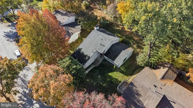 an aerial view of a house with a yard and large trees