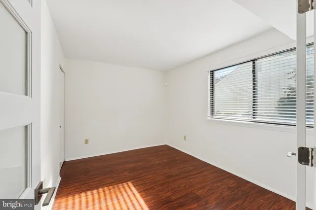 a view of a room with wooden floor and a window