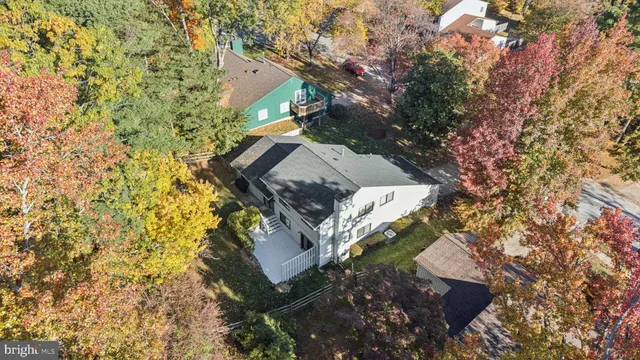 an aerial view of a house with a yard and large trees