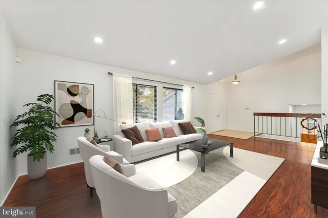 a living room with furniture potted plant and a wooden floor