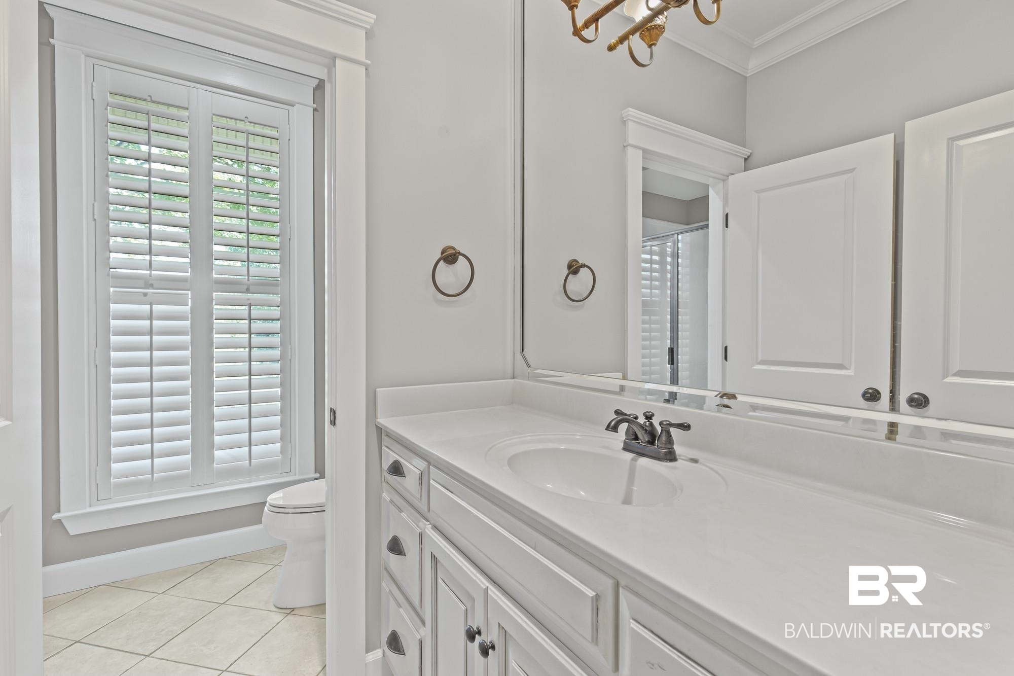 11261 Halcyon Loop Daphne, AL 36526 - Photo 21 of 41 Bathroom vanity featuring an integrated sink, broad mirror, and built-in cabinetry