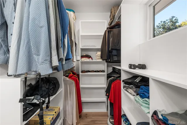 a view of walk in closet with clothes and shoes