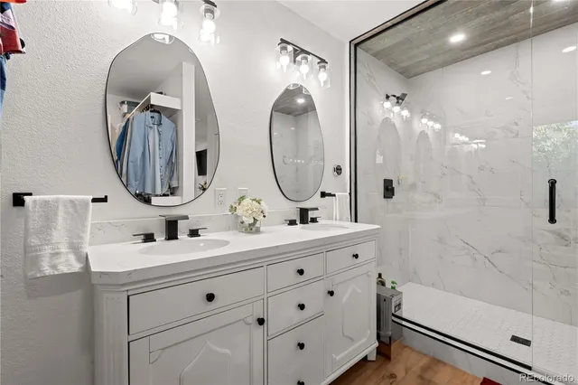 a bathroom with a double vanity sink mirror and bathtub