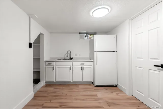 a kitchen with sink refrigerator and cabinets