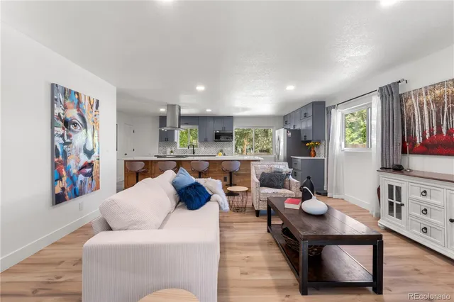 a living room with furniture kitchen view and a window