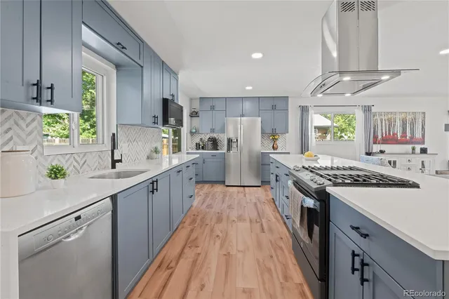 a kitchen with stainless steel appliances a sink stove and refrigerator