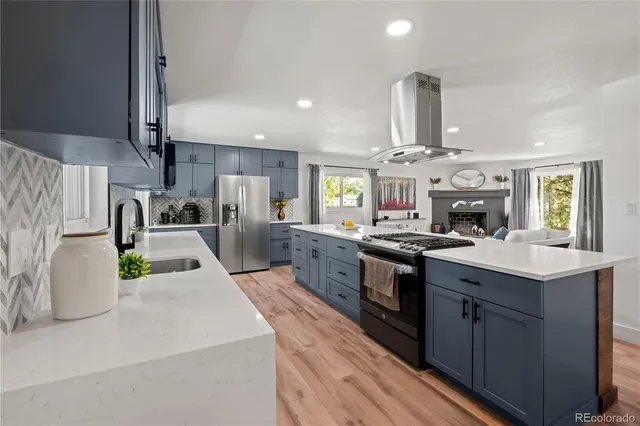 a kitchen with stainless steel appliances granite countertop a sink stove and refrigerator
