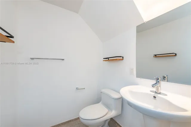 a bathroom with a sink a toilet and mirror