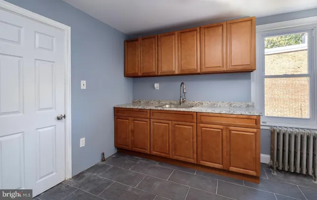 a kitchen with granite countertop cabinets sink and window