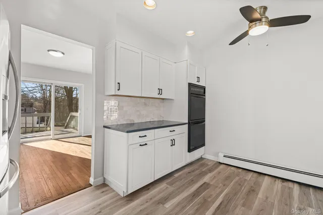 a kitchen with granite countertop white cabinets and white appliances