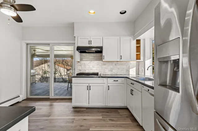 a kitchen with stainless steel appliances granite countertop a stove a sink and a refrigerator