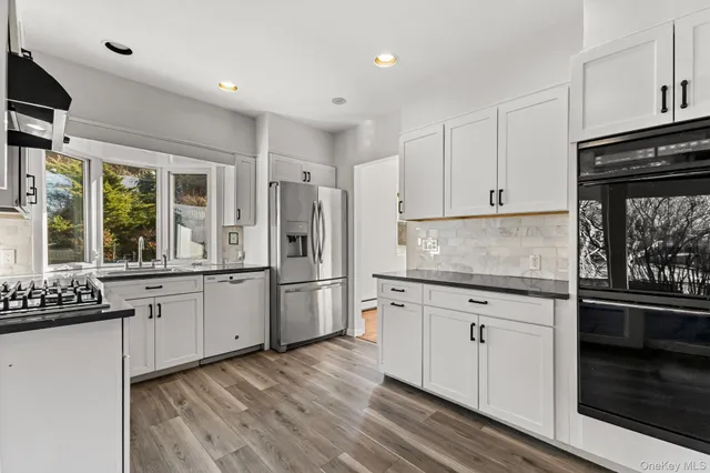 a kitchen with granite countertop a refrigerator stove top oven and sink