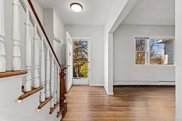 a view of an entryway with wooden floor and door