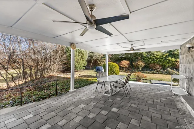 a view of a patio with a table and chairs under an umbrella