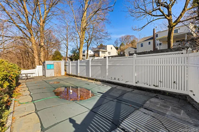 a view of a white house with a small yard and large tree
