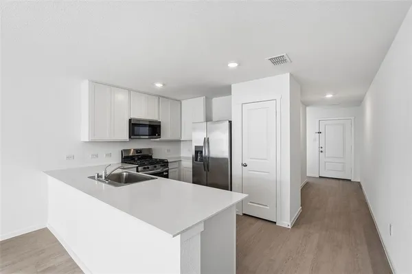 a kitchen with a refrigerator a sink a stove a microwave and cabinets