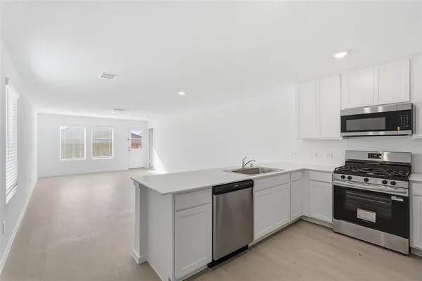 a kitchen with sink a microwave and cabinets