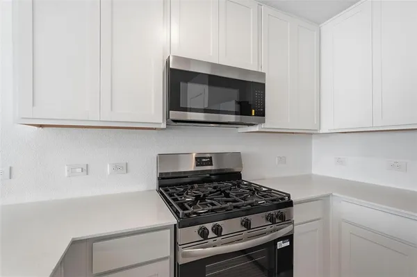 a kitchen with granite countertop a stove and a microwave