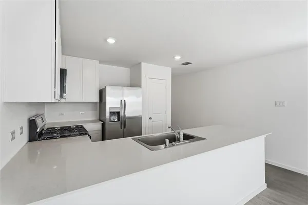 a kitchen with a refrigerator and a stove top oven