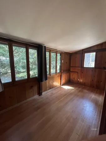 a view of empty room with wooden floor and cabinet