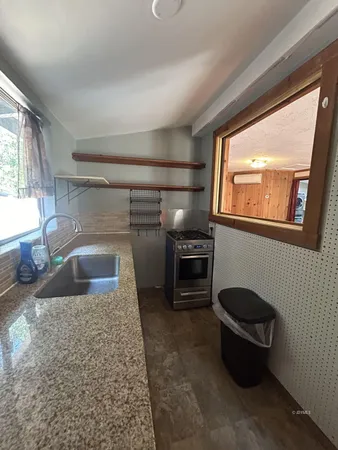 a kitchen with kitchen island a counter top space cabinets and stainless steel appliances
