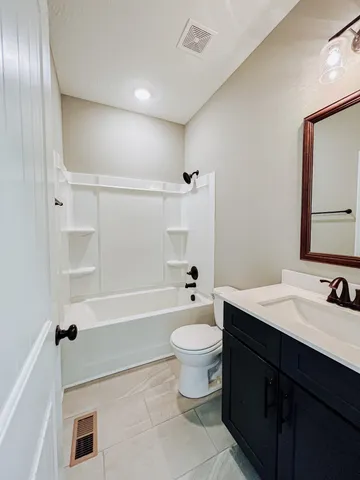 a bathroom with a sink a toilet a mirror and bathtub
