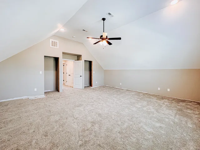 a view of a big room with ceiling fan and window