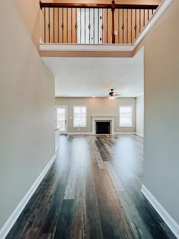 a view of empty room with wooden floor and fireplace