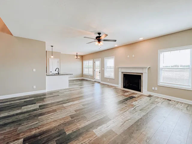 an empty room with windows and a fireplace