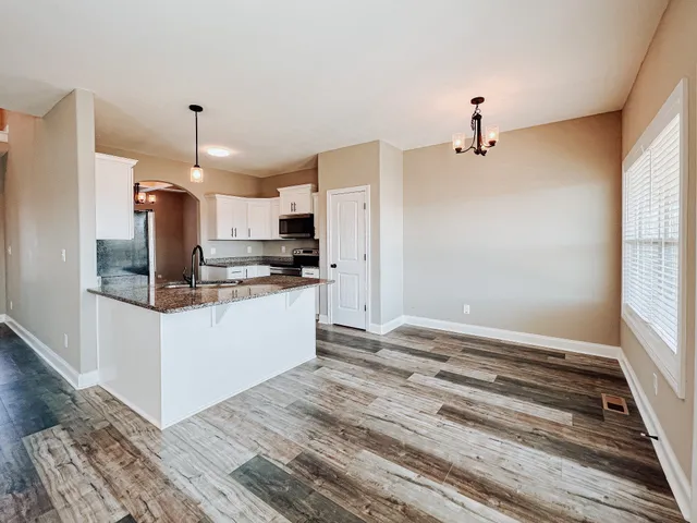 a kitchen with stainless steel appliances kitchen island granite countertop a refrigerator and a stove top oven