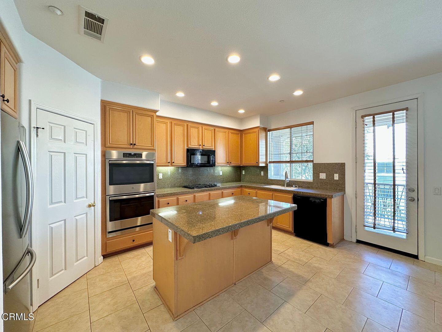 1202 Bayside Circle Oxnard, CA 93035 - Photo 13 of 48 a large kitchen with stainless steel appliances granite countertop a large counter top and a stove