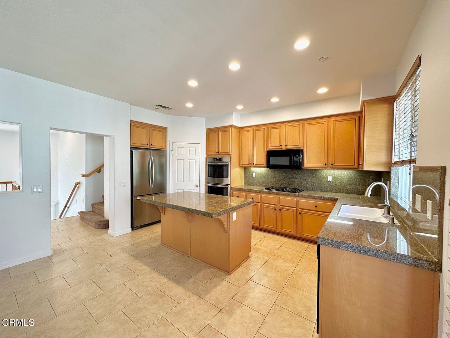 1202 Bayside Circle Oxnard, CA 93035 - Photo 14 of 48 a kitchen with stainless steel appliances granite countertop a refrigerator a sink a stove a microwave and island