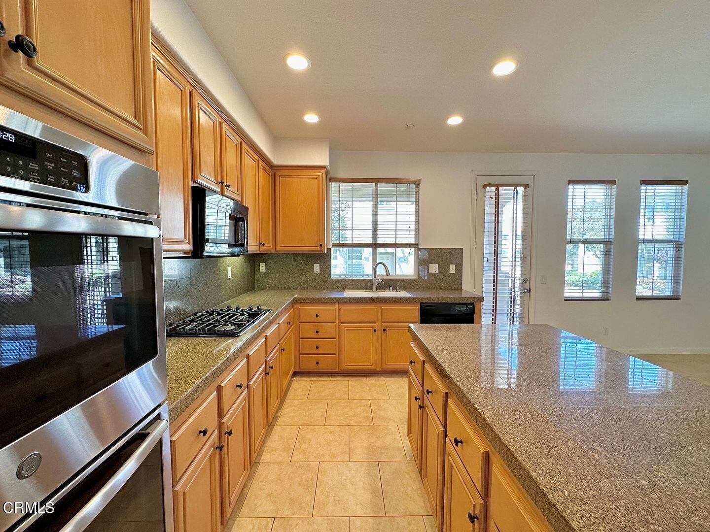 1202 Bayside Circle Oxnard, CA 93035 - Photo 15 of 48 a kitchen with stainless steel appliances granite countertop a stove and a sink