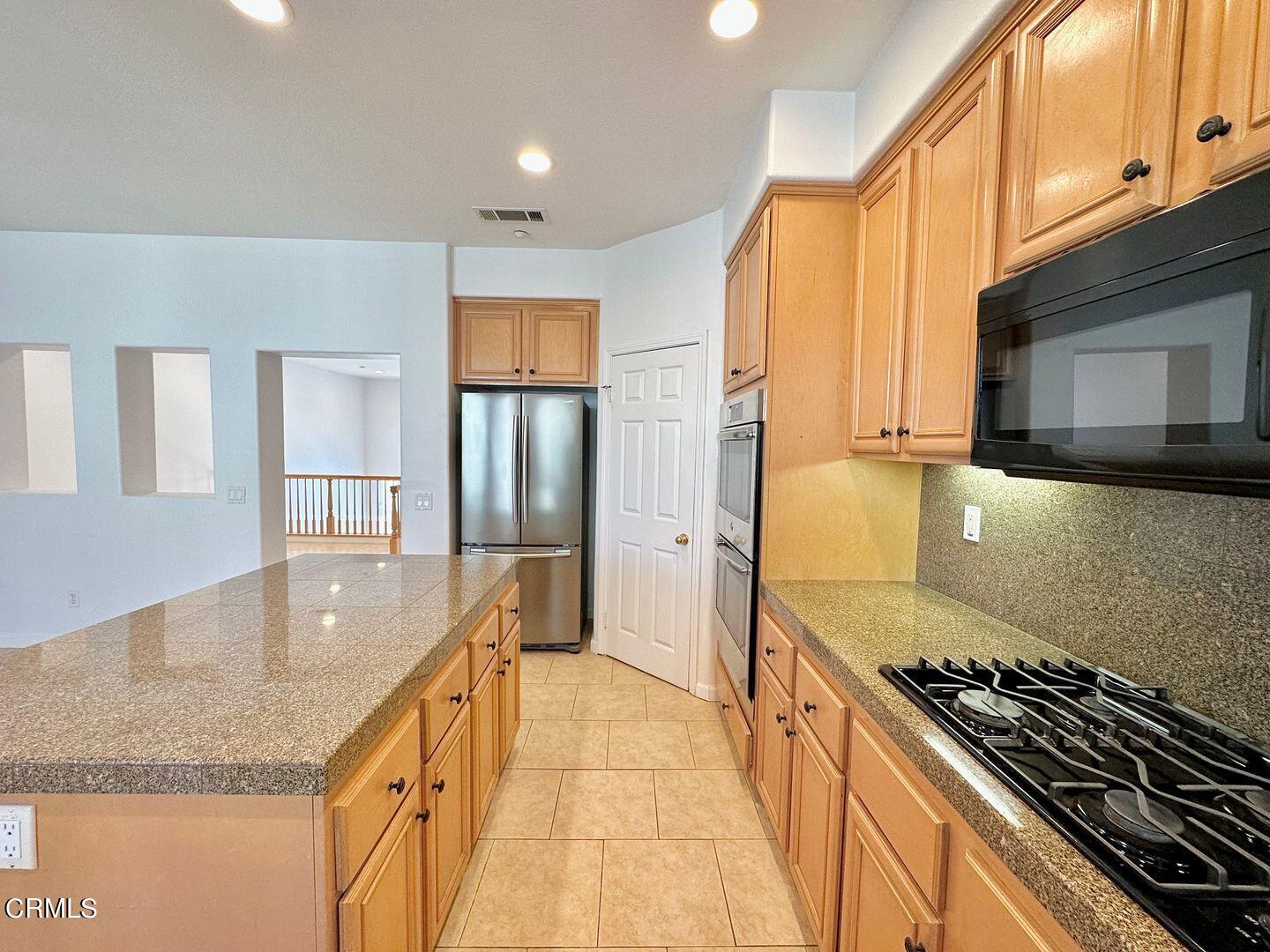 1202 Bayside Circle Oxnard, CA 93035 - Photo 16 of 48 a kitchen with granite countertop a stove and a sink