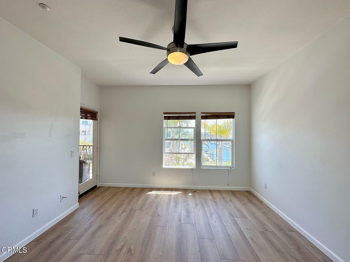 1202 Bayside Circle Oxnard, CA 93035 - Photo 27 of 48 an empty room with wooden floor a ceiling fan and windows