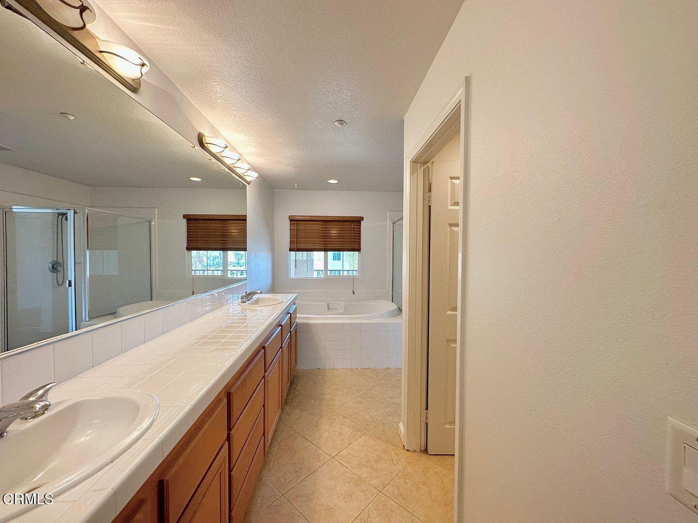 1202 Bayside Circle Oxnard, CA 93035 - Photo 29 of 48 a spacious bathroom with a granite countertop sink mirror and bathtub