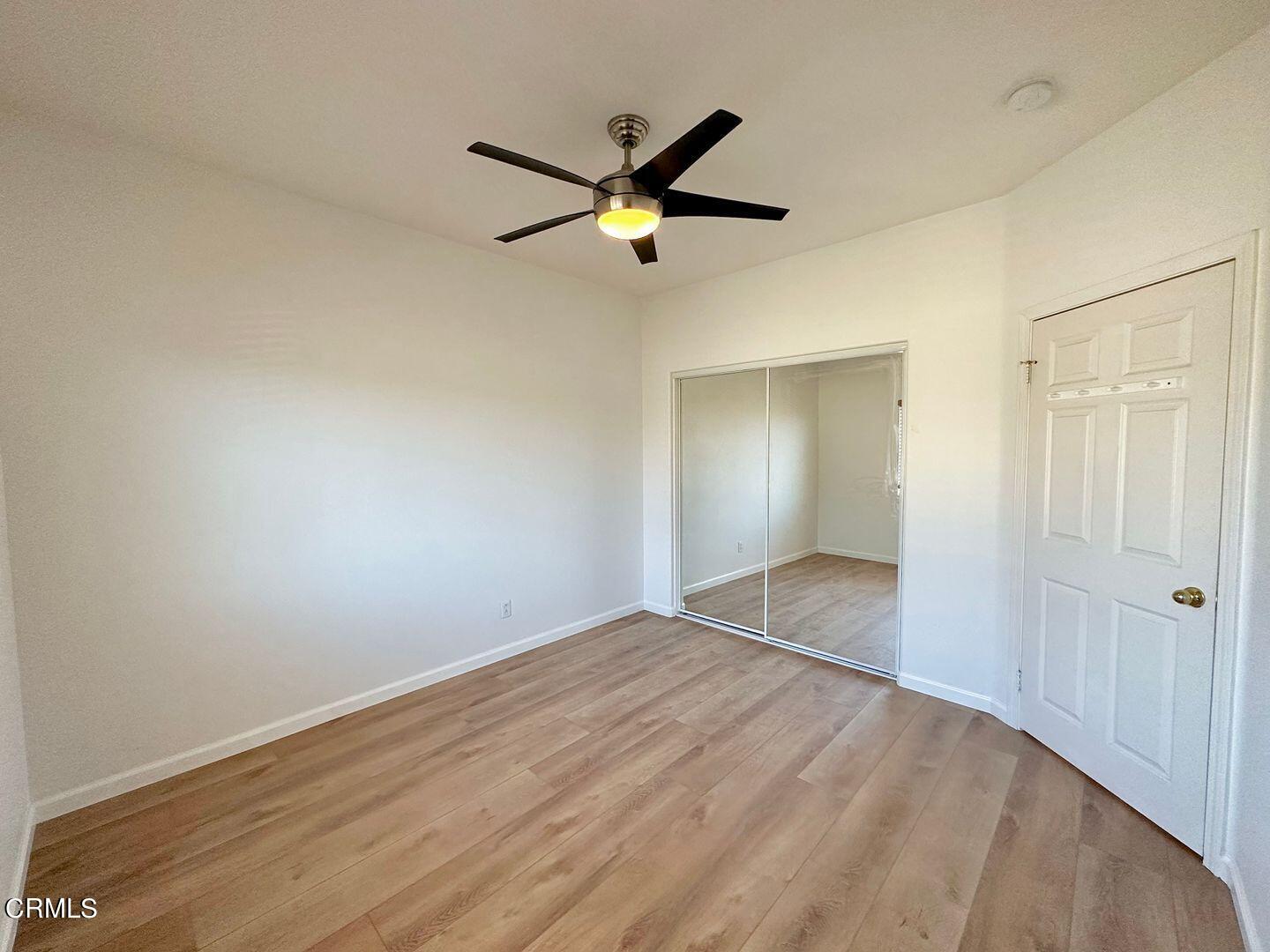 1202 Bayside Circle Oxnard, CA 93035 - Photo 36 of 48 a view of empty room with wooden floor and a ceiling fan