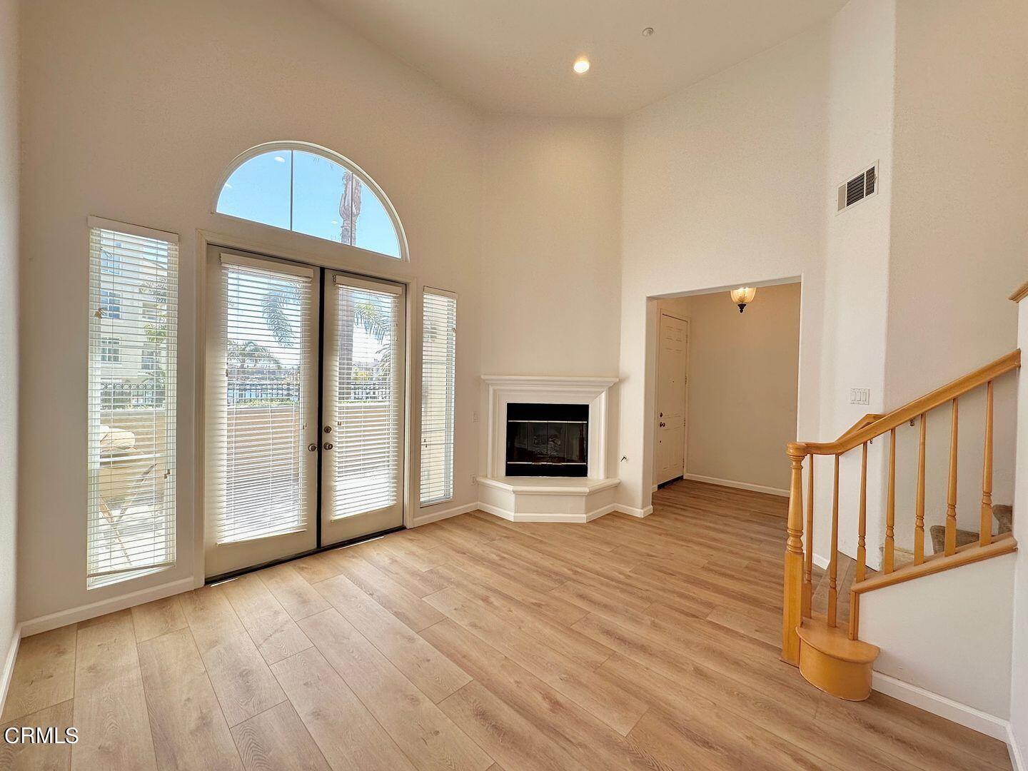 1202 Bayside Circle Oxnard, CA 93035 - Photo 7 of 48 a view of an empty room with wooden floor fireplace and a window