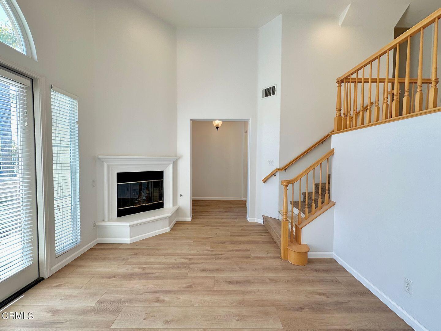 1202 Bayside Circle Oxnard, CA 93035 - Photo 9 of 48 a view of an entryway with wooden floor and a fireplace