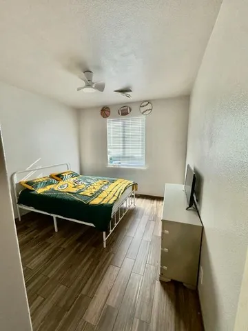 a bedroom with a bed and wooden floor
