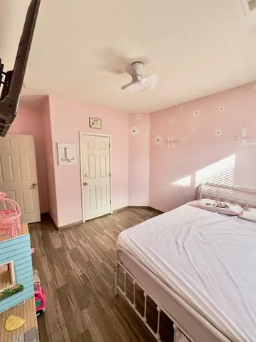 a bedroom with a bed and a refrigerator