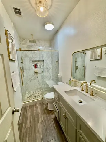 a bathroom with a sink mirror vanity and toilet