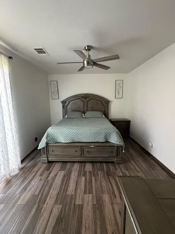 a bedroom with a bed and wooden floor