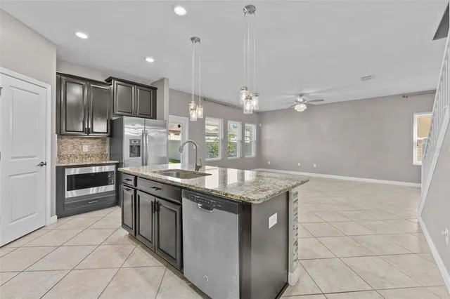 a kitchen with stainless steel appliances granite countertop a sink and a refrigerator