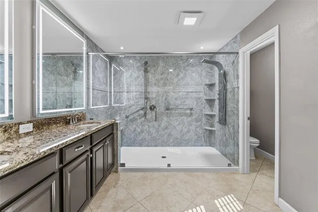 a bathroom with a granite countertop bathtub shower and sink