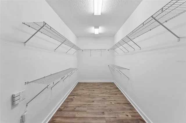 a view of a hallway with the white walls and wooden floor