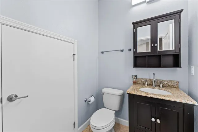 a bathroom with a sink vanity mirror and toilet