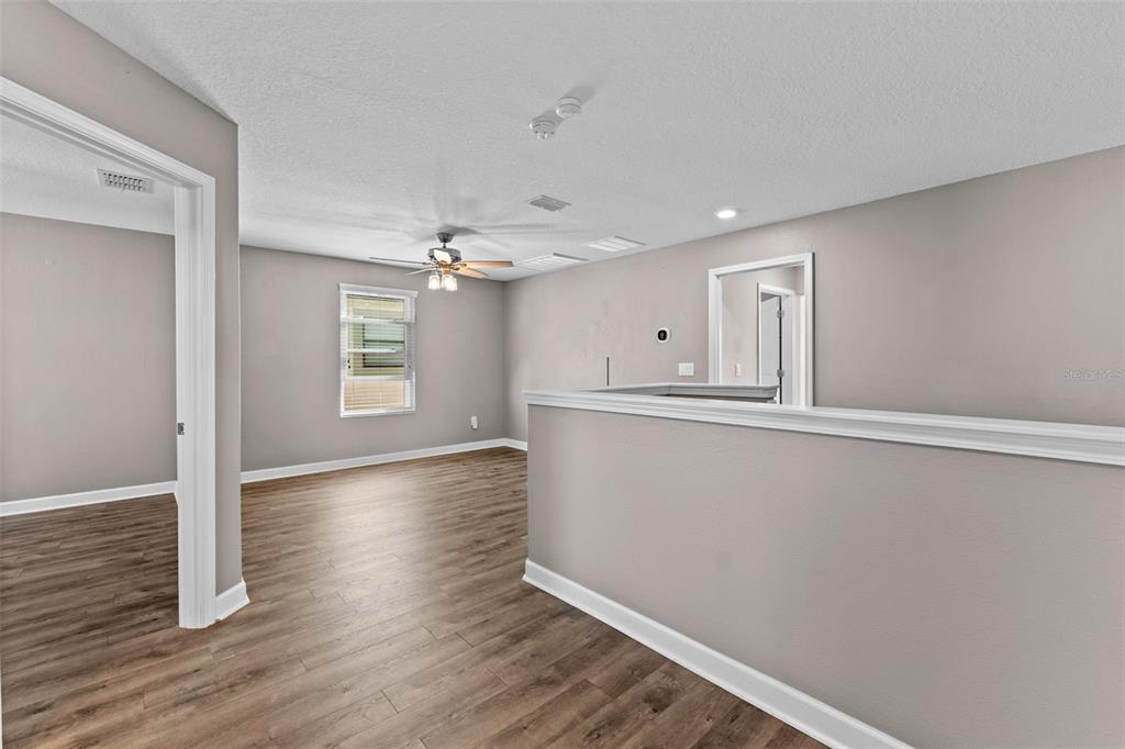 1040 Oliveto Verdi Court Brandon, FL 33511 - Photo 4 of 35 an empty room with wooden floor and windows