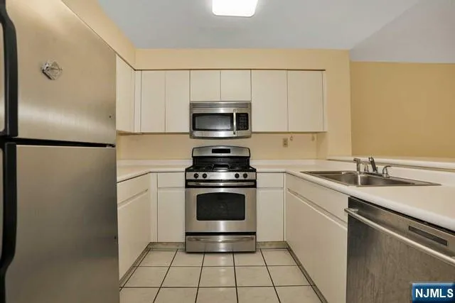 a kitchen with a sink stainless steel appliances and cabinets